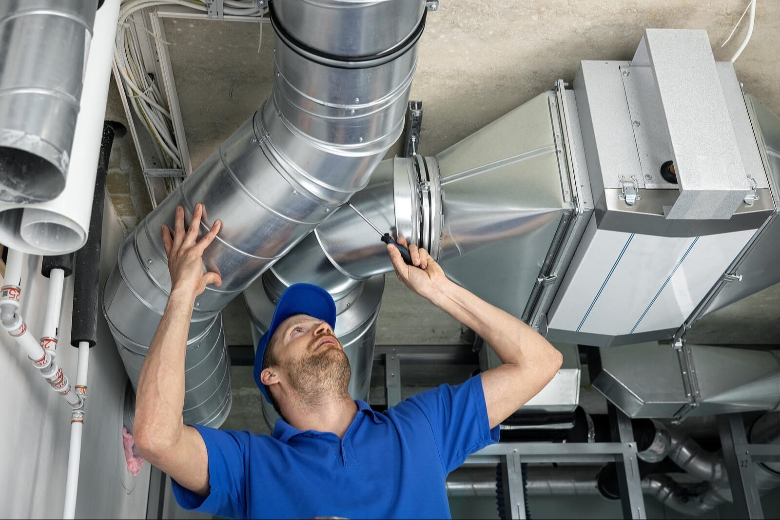 A technician installing ductwork.