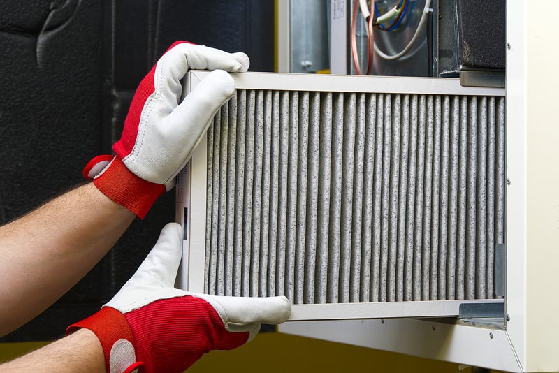 A furnace filter in the process of being changed.