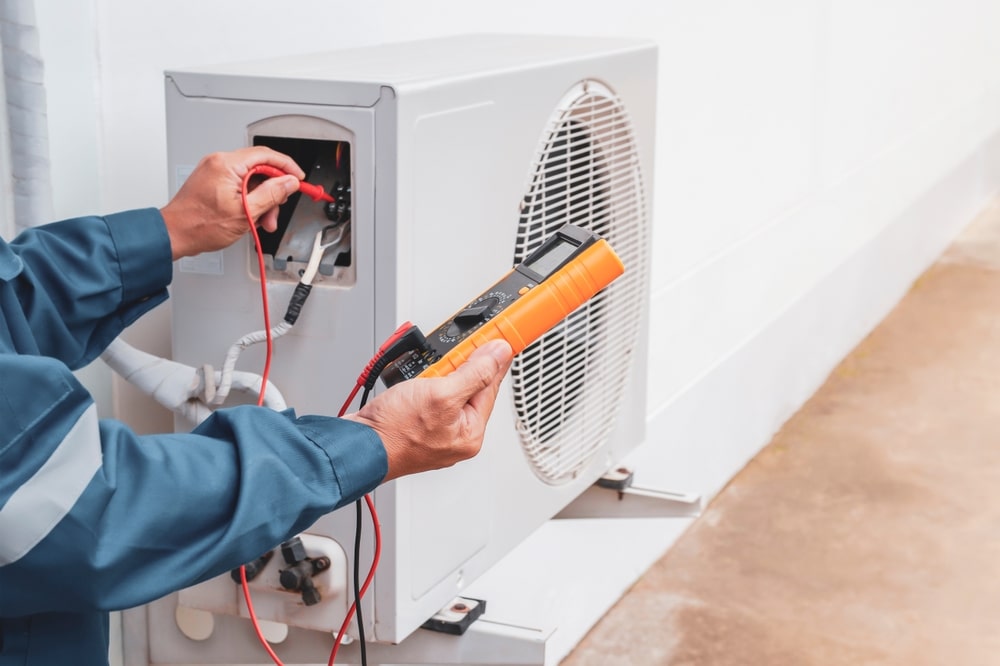 Technician performing maintenance on a HVAC system.