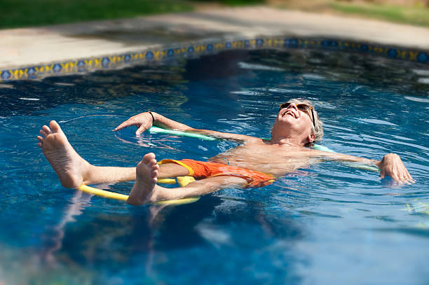 A person in a swimming pool lying on a float.