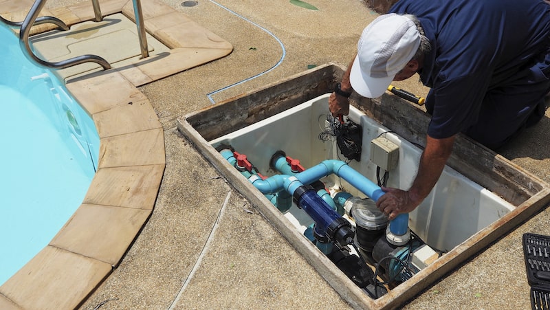 A technician performing pool heater maintenance.