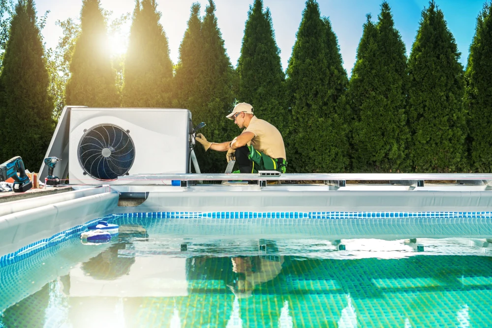 A technician working on a pool heater, with the pool in the foreground.